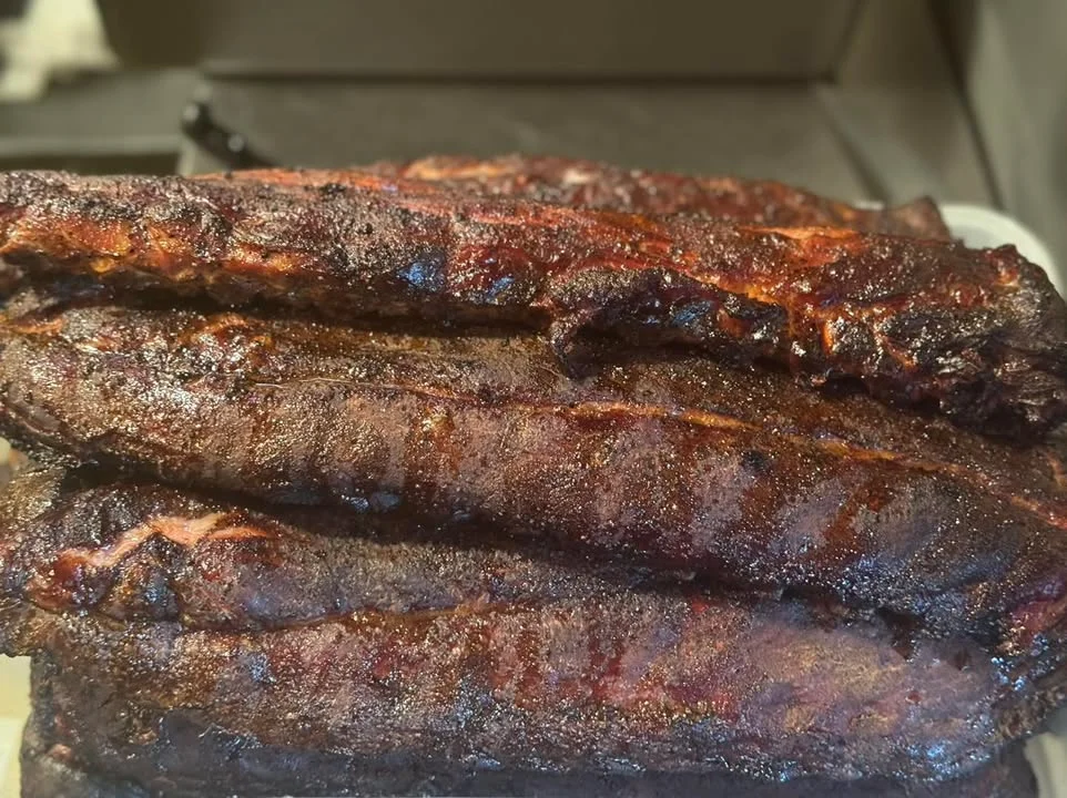 Smoked barbecue ribs stacked high on a platter